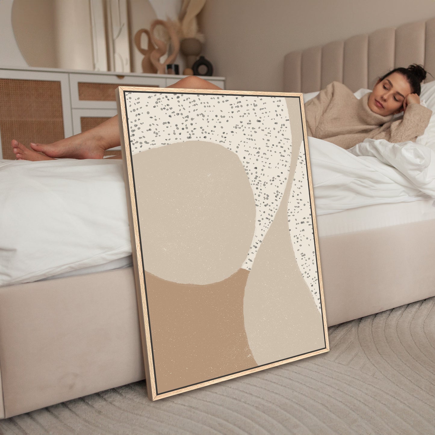 a woman laying on a bed next to a picture frame