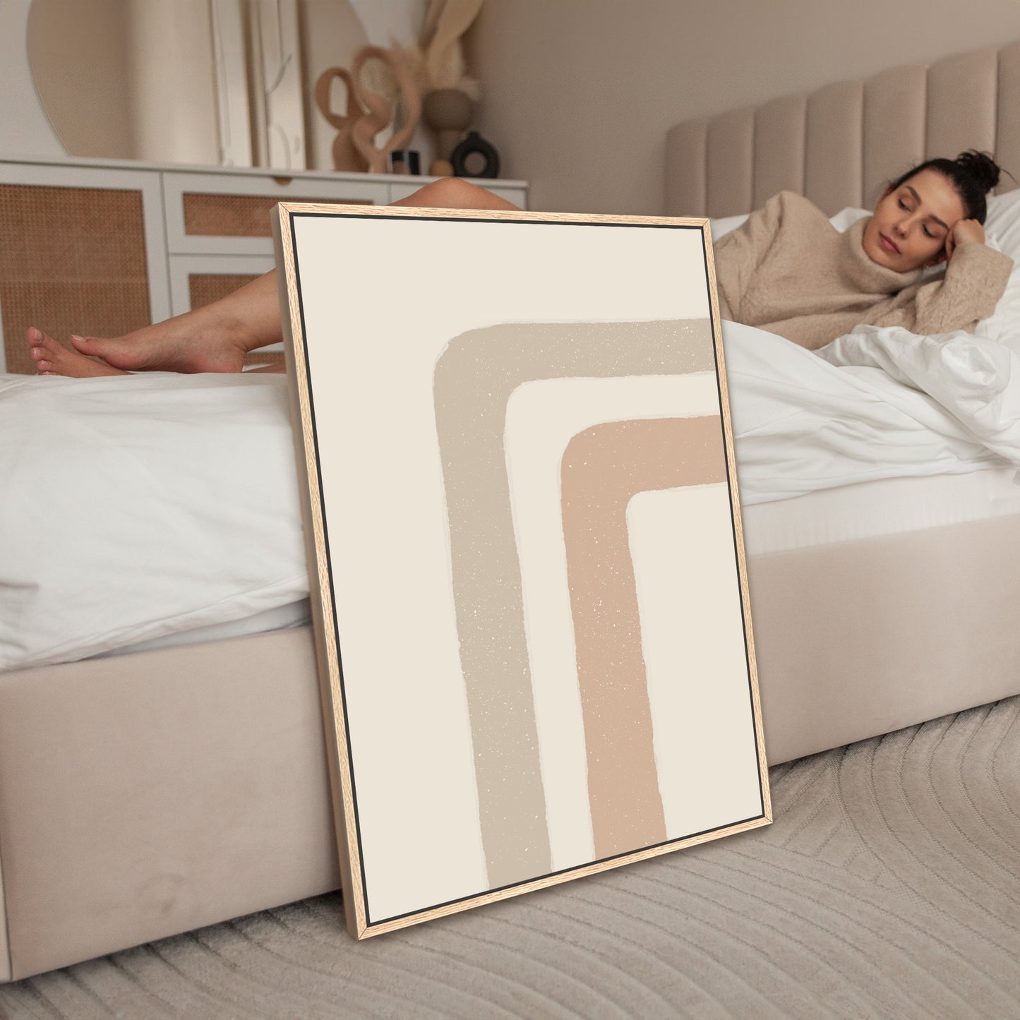 a woman laying on a bed next to a picture frame