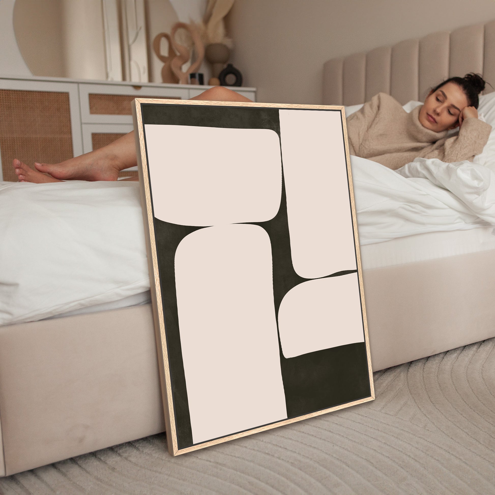 a woman laying on a bed next to a picture frame